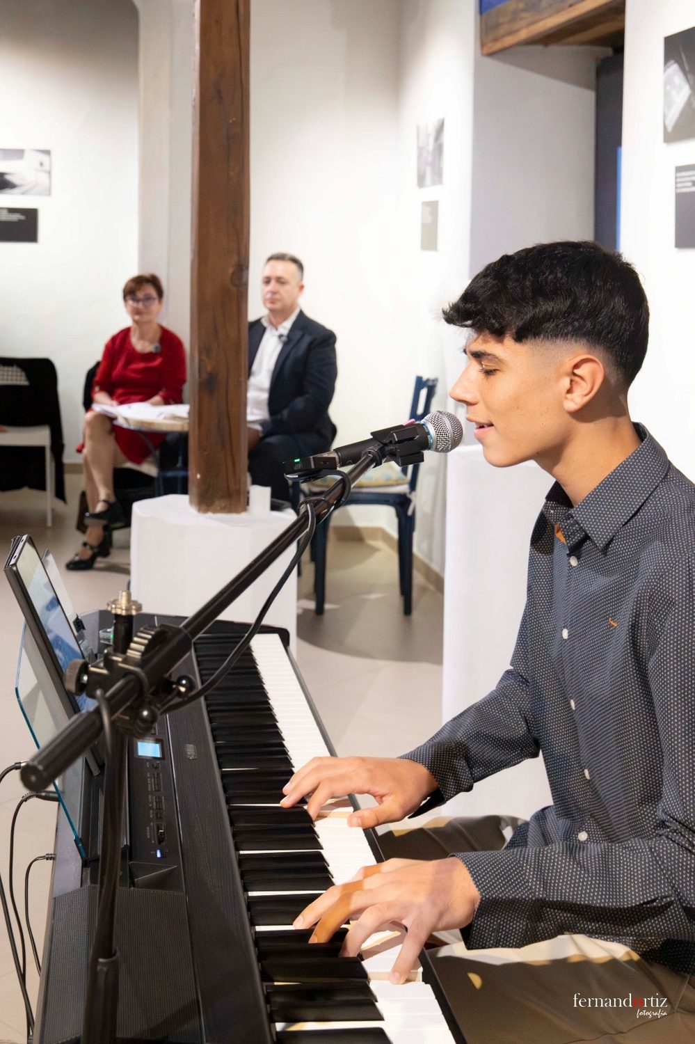 Un joven pianista cantando y tocando el teclado durante la presentación